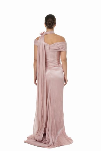 فستان سهرة بمقاسات كبيرة، بلون وردي فاتح، بياقة واسعة، وتفاصيل شال طويل، وتطريزات زهرية، وكسرات 